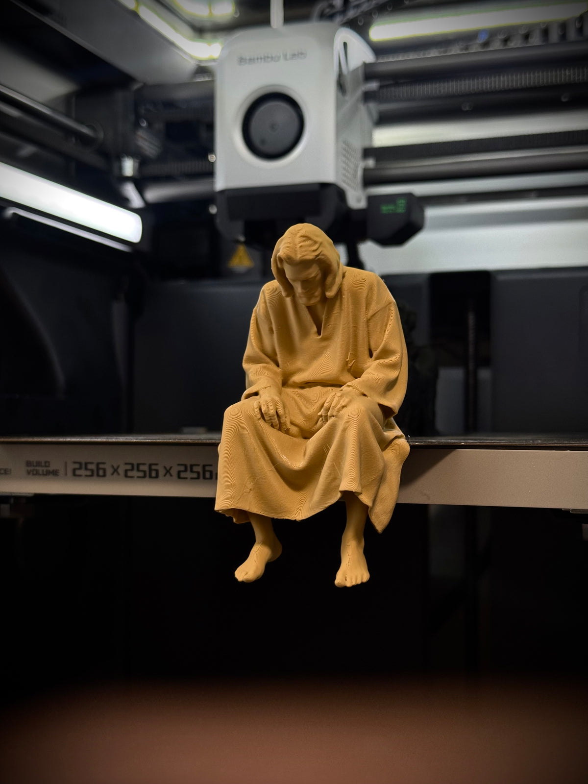 Figur Jesus traurig auf Kante sitzend
